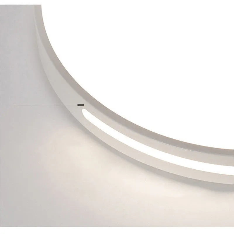 Round modern acrylic LED ceiling lamp with remote control on a white bedroom ceiling.