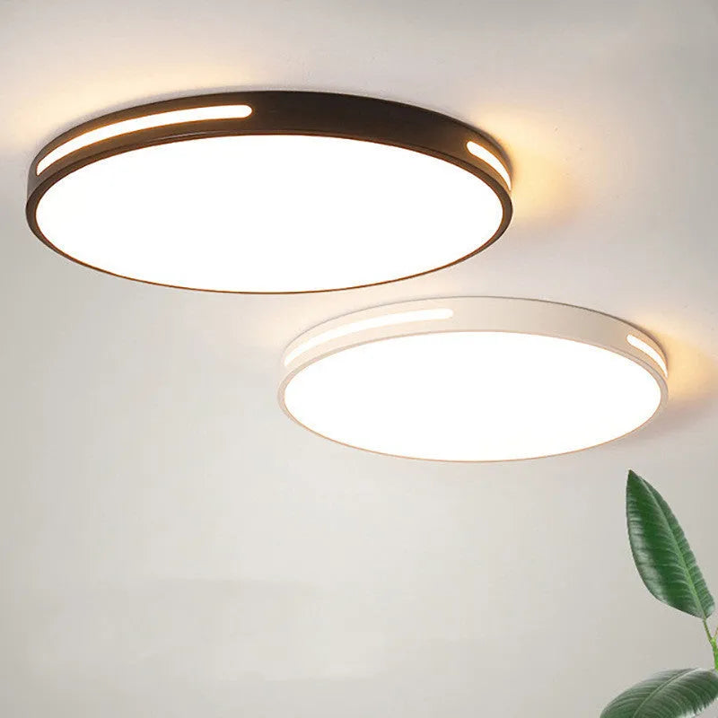 Round modern acrylic LED ceiling lamp with remote control on a white bedroom ceiling.