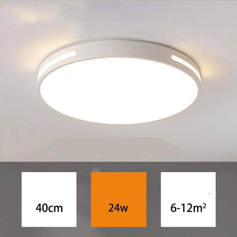Round modern acrylic LED ceiling lamp with remote control on a white bedroom ceiling.