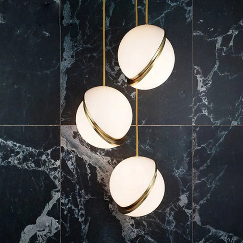 Nordic pendant light with white ball lampshade and golden fixture showing adjustable height mechanism