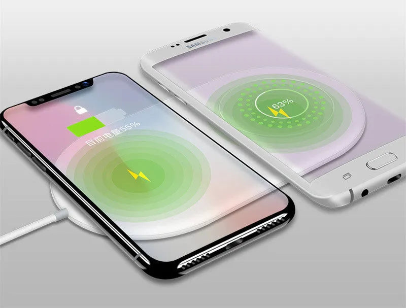 White dual wireless charger charging two mobile phones simultaneously on a simple charging pad
