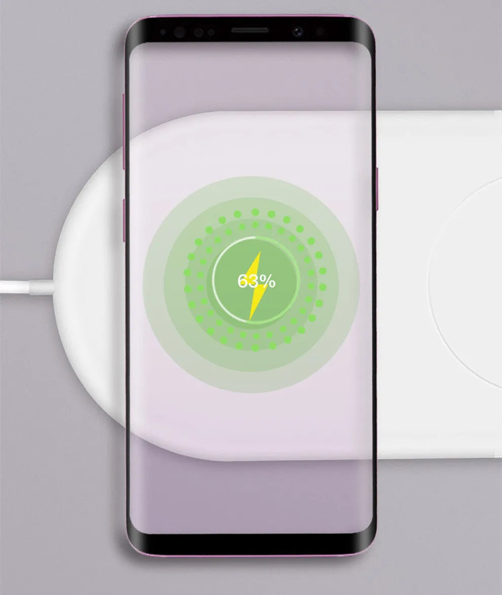 White dual wireless charger charging two mobile phones simultaneously on a simple charging pad