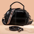 Round leather handbag in wine red with zipper opening and soft handle measuring 21cm wide