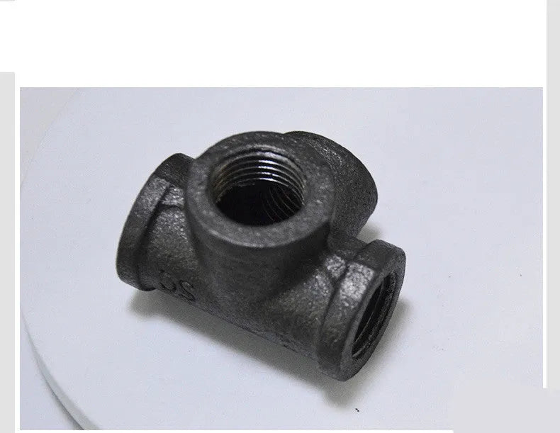 Galvanised steel four-way pipe fitting with three-dimensional corner design for industrial plumbing connections