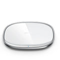 Square black 15W wireless phone charger with a glass top and zinc alloy frame on a desk.