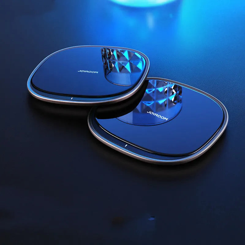 Square black 15W wireless phone charger with a glass top and zinc alloy frame on a desk.