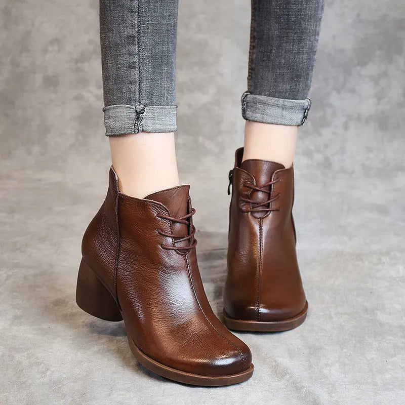 Women's brown leather Martin boots with a thick block heel and round toe on a white background.