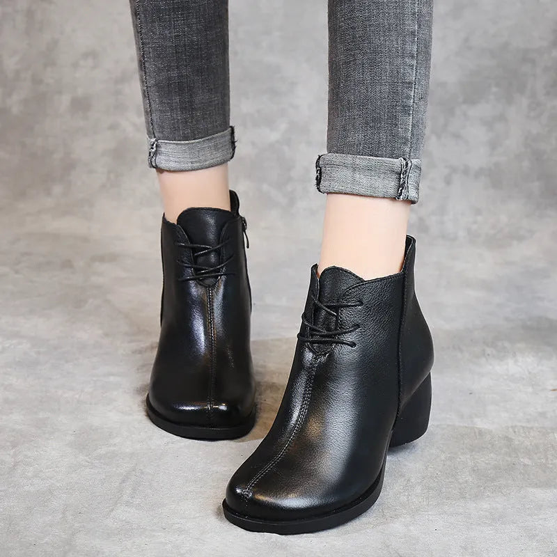 Women's brown leather Martin boots with a thick block heel and round toe on a white background.