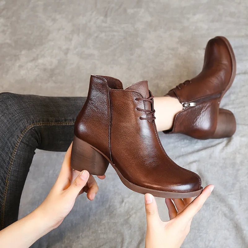 Women's brown leather Martin boots with a thick block heel and round toe on a white background.