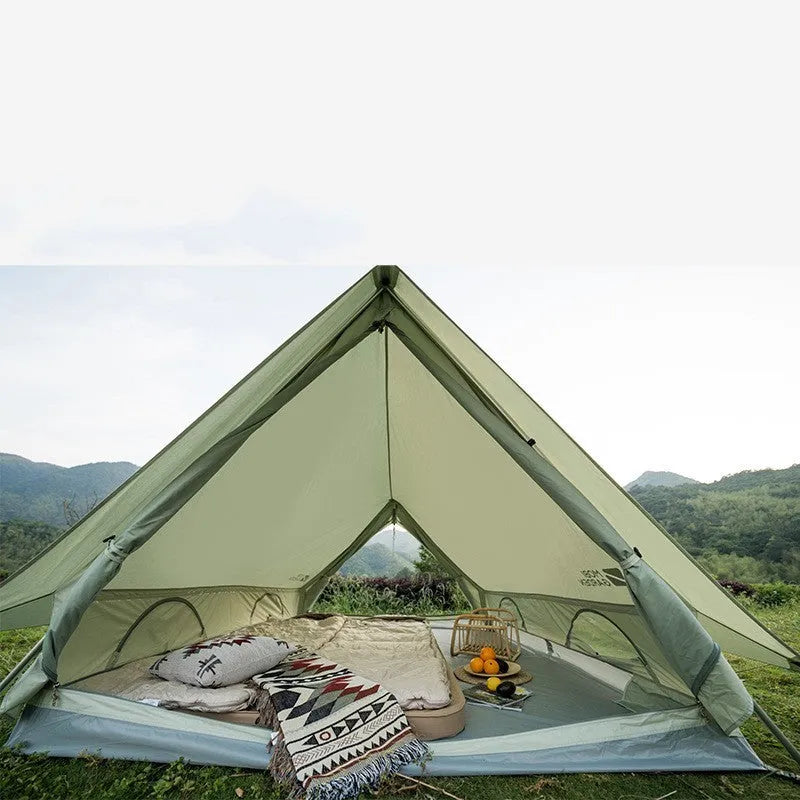 Large light luxury family camping tent in ivory white with cotton-polyester outer and aluminium poles set up outdoors