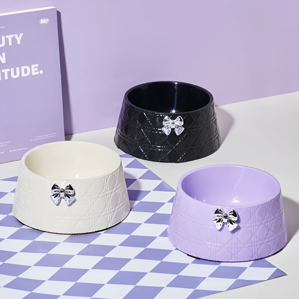 Set of four pet food bowls with bowknot design and diamond pattern in pink, silver, black, purple, and white colours.