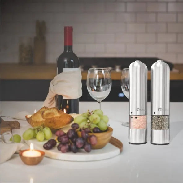 Stainless steel electric spice grinder with ceramic burrs on a kitchen counter.