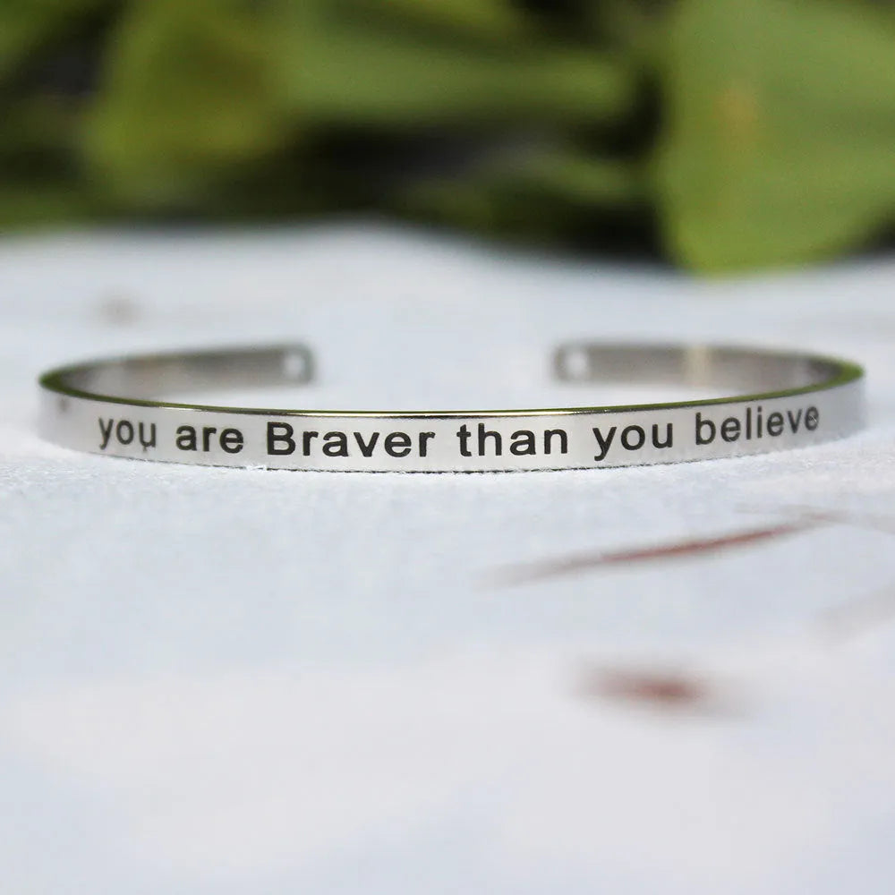 Silver customisable stainless steel bracelet with laser engraved text and adjustable fit on neutral background