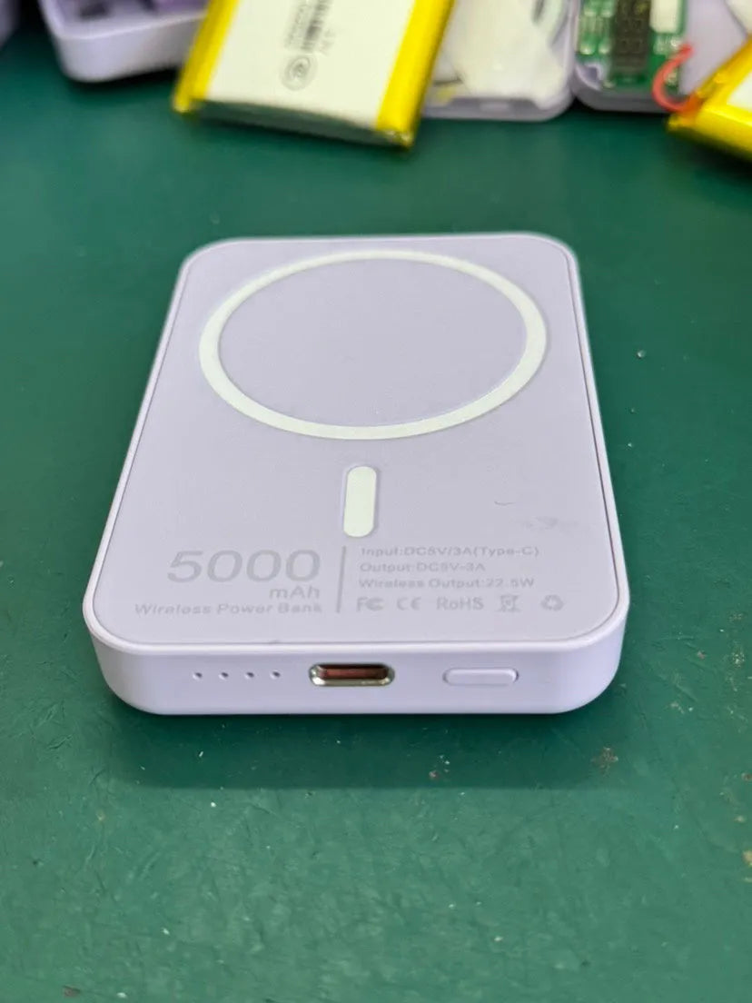 White magnetic wireless charging power bank with 5000mAh capacity on a table.