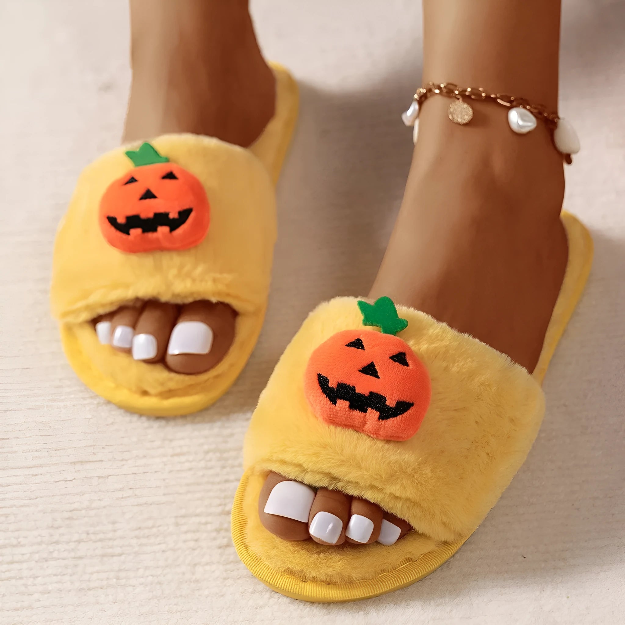 Yellow Halloween pumpkin cartoon design plush slippers with synthetic fur and a light-coloured sole.