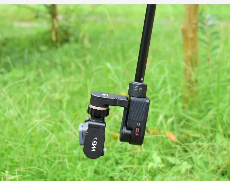 Retractable aluminium selfie stick extended to 1 metre with phone attached and Bluetooth remote in hand