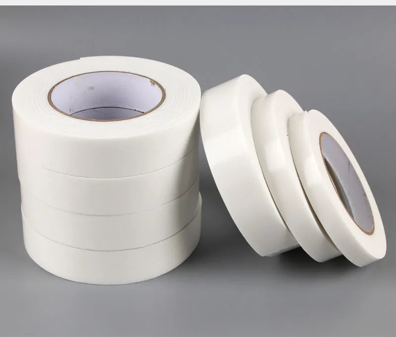 Roll of 3mm thick white foam double-sided adhesive tape showing its spongy core and strong adhesive on both sides.