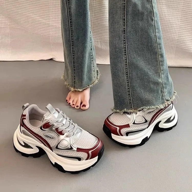 Women's red clunky platform sneakers with mesh lining and rubber sole on a white background.
