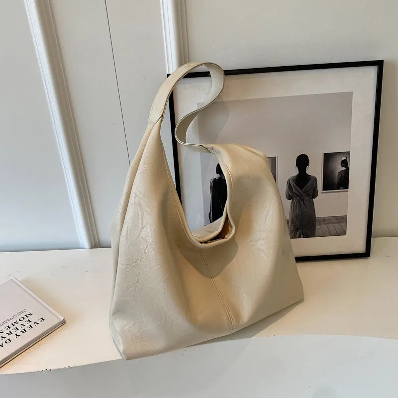 Casual soft PU leather shoulder bag in black with visible stitching and a front sandwich pocket.