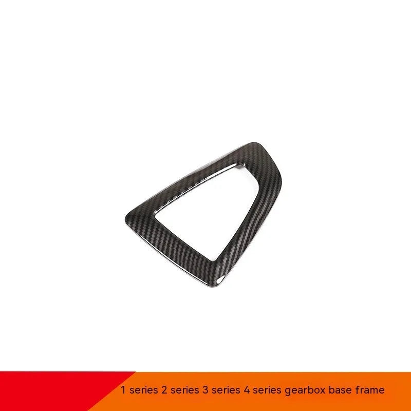 BMW gear base frame in left titanium colour with carbon fibre pattern, showing 3M adhesive backing.