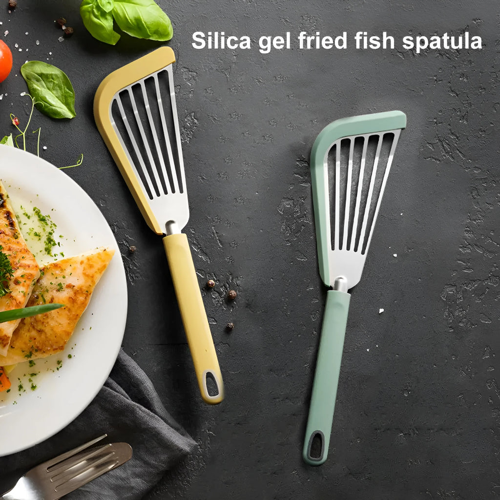 Green silicone fish spatula with 1mm thin slotter blade and hanging hole on a kitchen counter