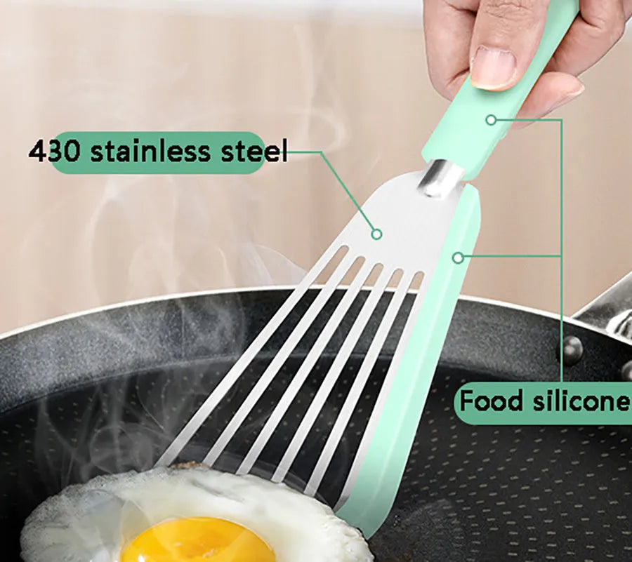 Green silicone fish spatula with 1mm thin slotter blade and hanging hole on a kitchen counter