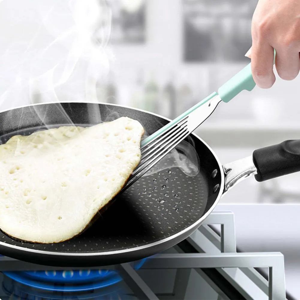 Green silicone fish spatula with 1mm thin slotter blade and hanging hole on a kitchen counter