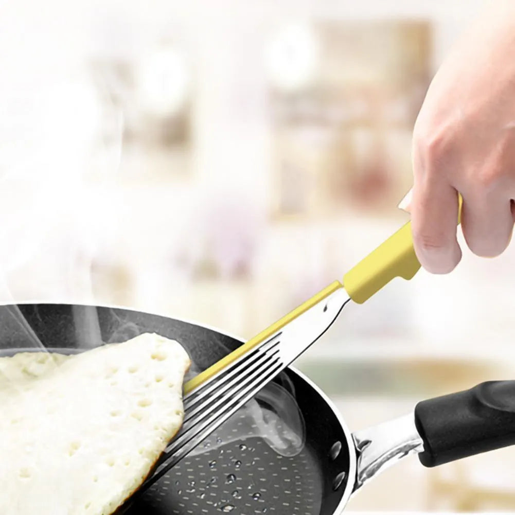Green silicone fish spatula with 1mm thin slotter blade and hanging hole on a kitchen counter