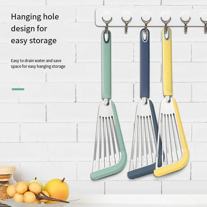Green silicone fish spatula with 1mm thin slotter blade and hanging hole on a kitchen counter