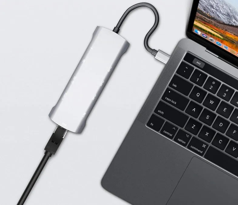 Grey aluminium USB-C docking station with HDMI, VGA, USB 3.0, and USB-C PD charging ports.