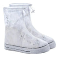 Waterproof PVC shoe covers in transparent dot white, non-slip sole, adult size, lying on a dry surface
