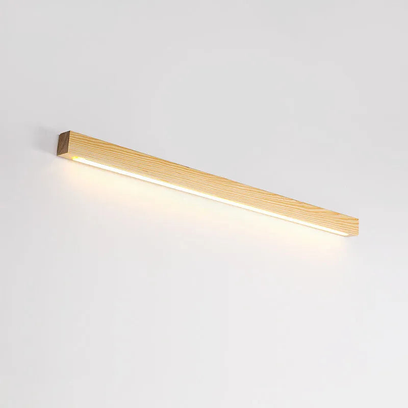 Slim walnut-coloured wood and acrylic LED strip wall lamp mounted on a wall in a modern room.