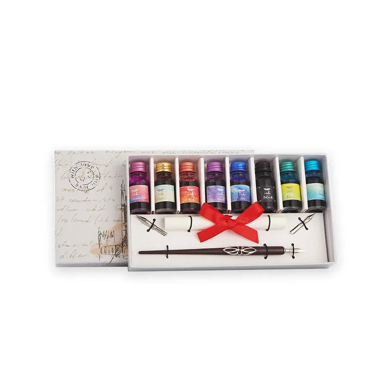 Wooden gift box open to show a dip pen, bottles of coloured ink, spare nibs, and a standing pen holder.