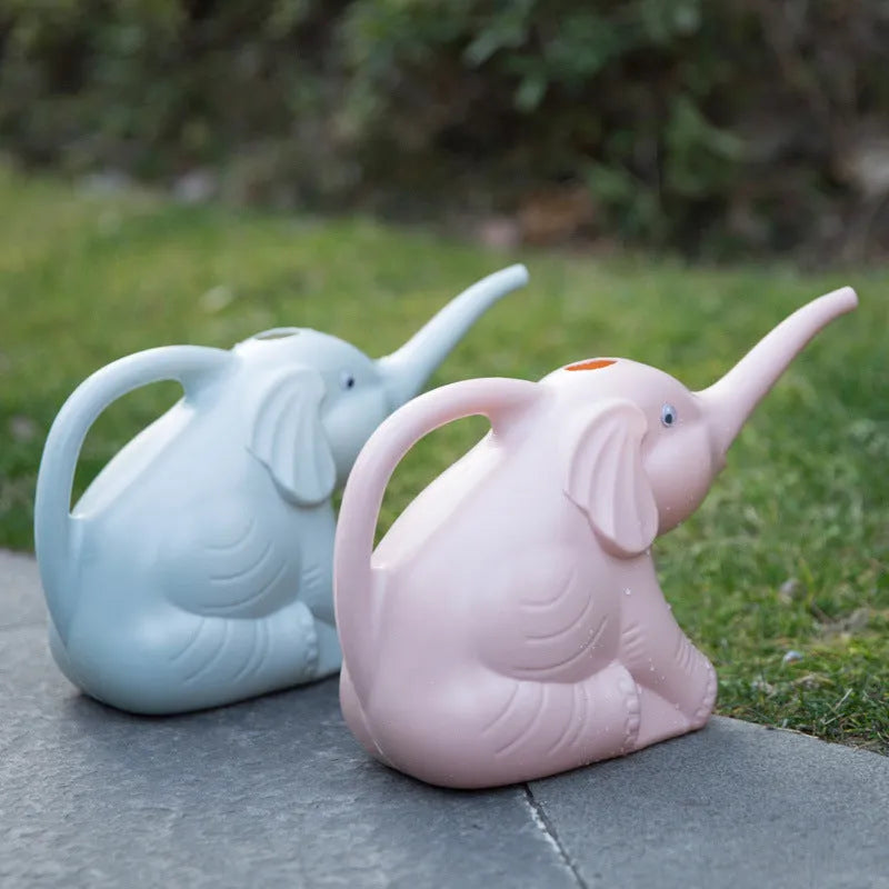 Pink baby elephant-shaped watering can with a long nozzle and bottle-style handle on a table.