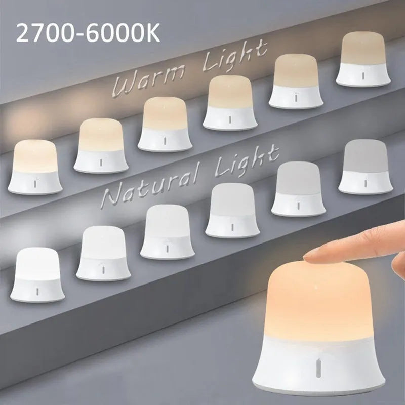 White rechargeable touch-control bedside night light with motion sensor on a table.