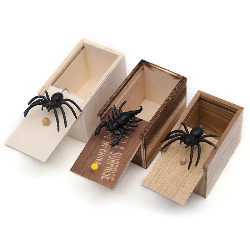 Wooden prank scare box with lid open showing a lifelike spider figurine on a spring.