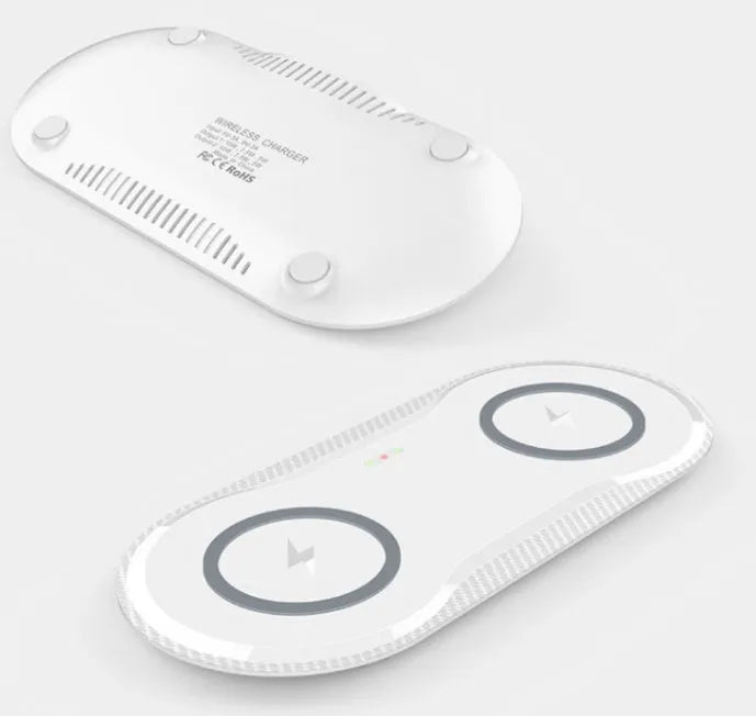 Black dual wireless charging pad showing two smartphones charging simultaneously on a desk.