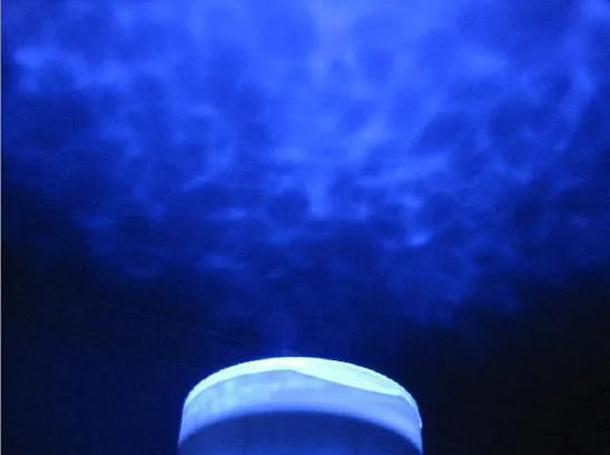 Blue ocean theme LED projection lamp for children's rooms on a wooden surface.