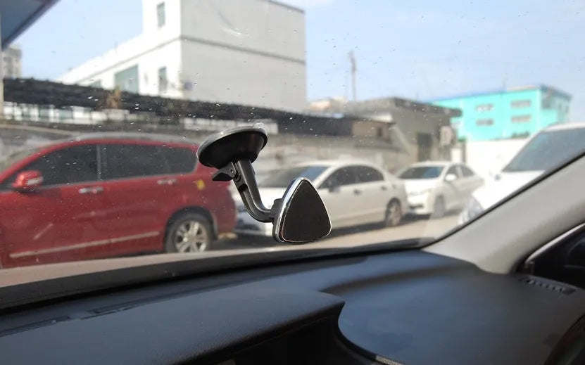 Black magnetic car phone holder with 360-degree rotating bracket mounted on dashboard