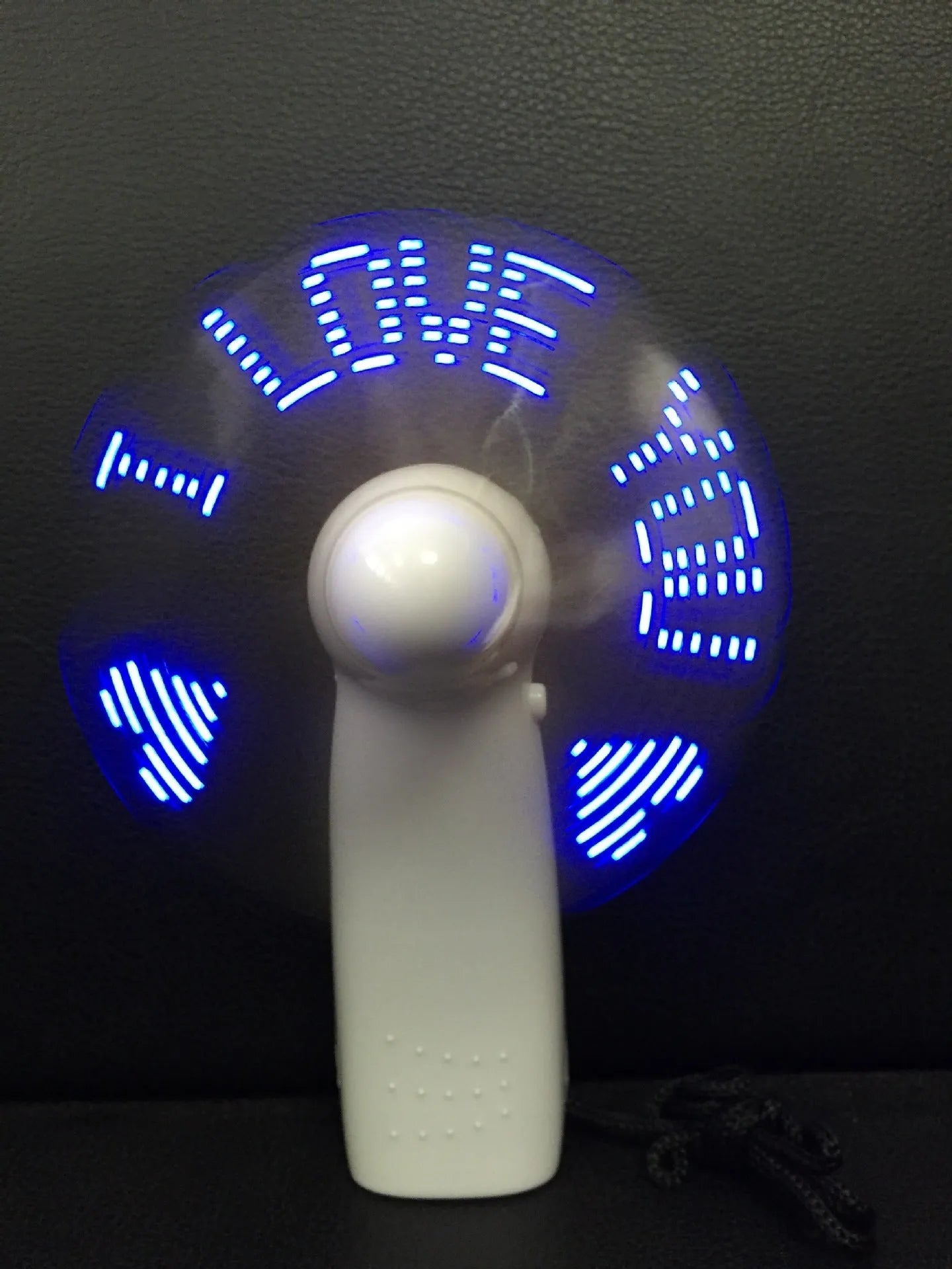 White handheld mini fan with blue and red LED flashing I love you pattern, showing dimensions.