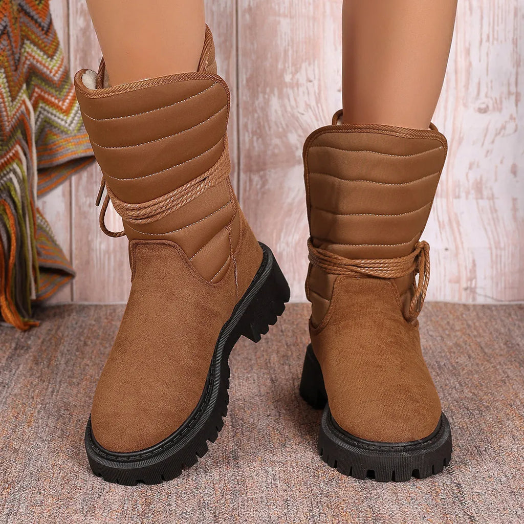 Women's chunky heel snow boots in suede with lace-up design and fleece lining, shown in black.