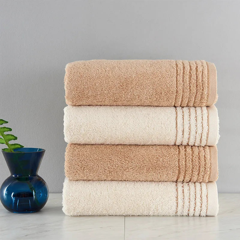 Beige and brown cotton bath towel set showing large bath towel, hand towel, and small face cloth.