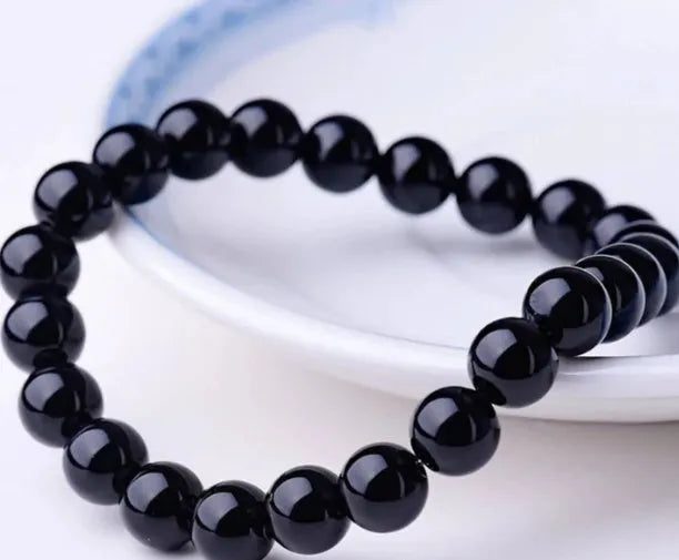 Geometric black agate bead bracelet with elastic cord, showing 8mm bead size detail.