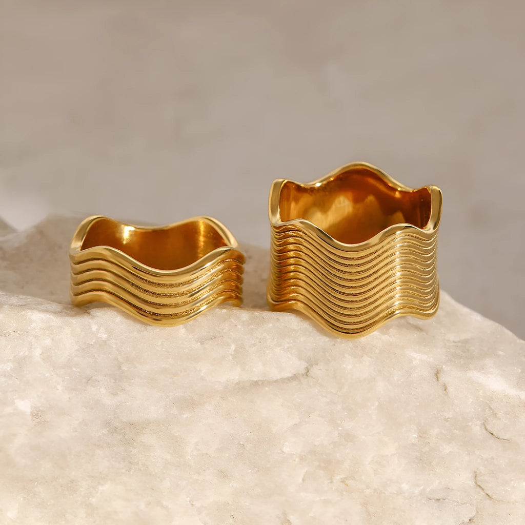 Stainless steel geometric wave ring with wide band design in silver and gold colour options.