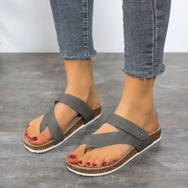 Blue thick-soled flip-flops with a flat toe ring on a light background