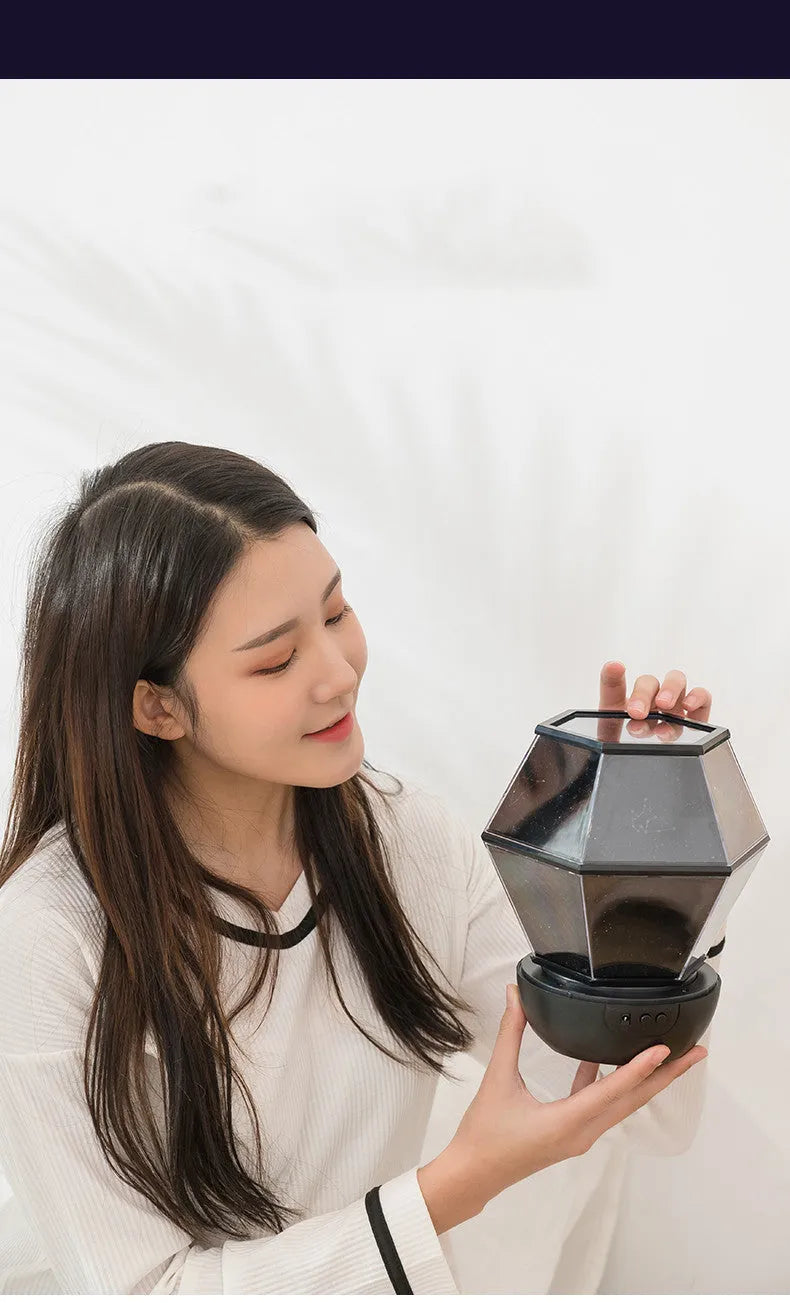Children's rotating star night light projecting coloured stars on bedroom wall