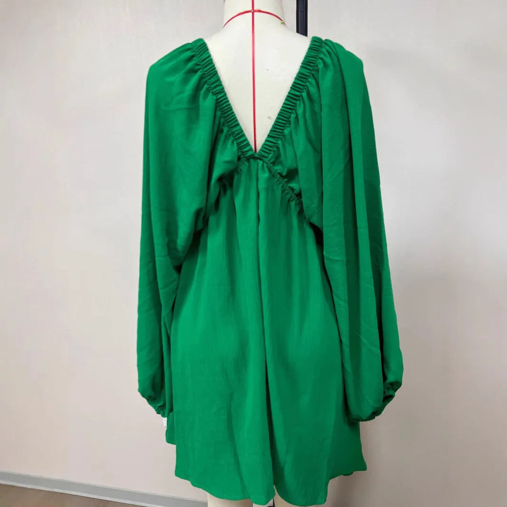 Women's apricot V-neck long-sleeve dress with puff sleeves and a flounce swing skirt on a hanger.