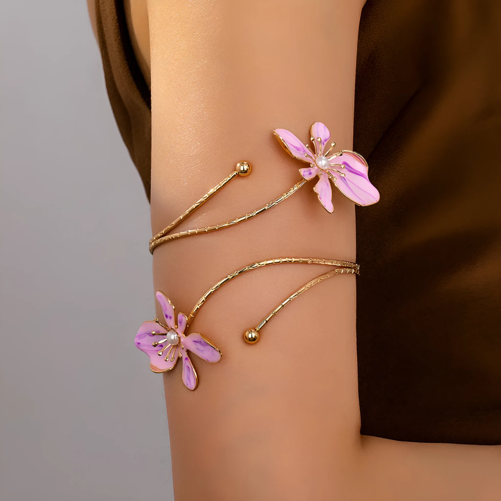 Pink and purple adjustable alloy hollow pattern armband on a wrist.