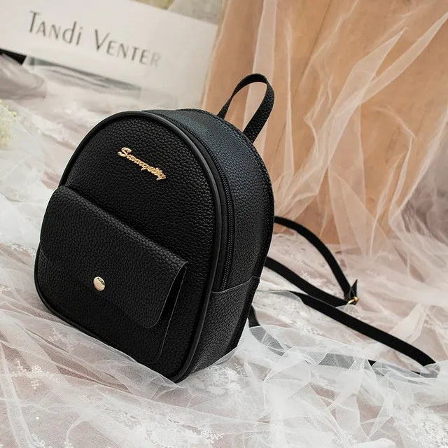 A compact black PU women's backpack purse with a zipper, shown as a small shoulder bag.