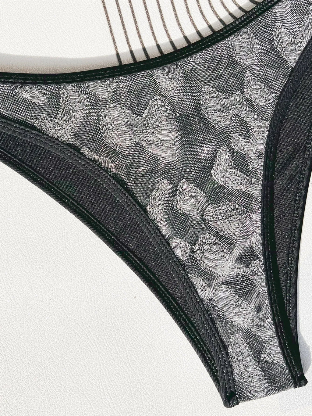 Black two-piece ladies bikini swimsuit with straps, made from polyester fabric.